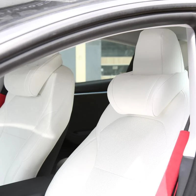 White seat neck pillows on both front seats of a white Tesla interior