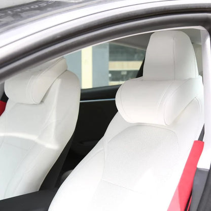White seat neck pillows on both front seats of a white Tesla interior