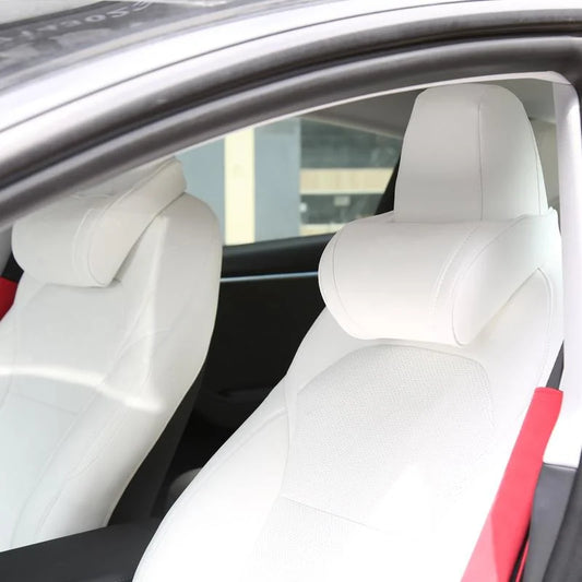 White seat neck pillows on both front seats of a white Tesla interior