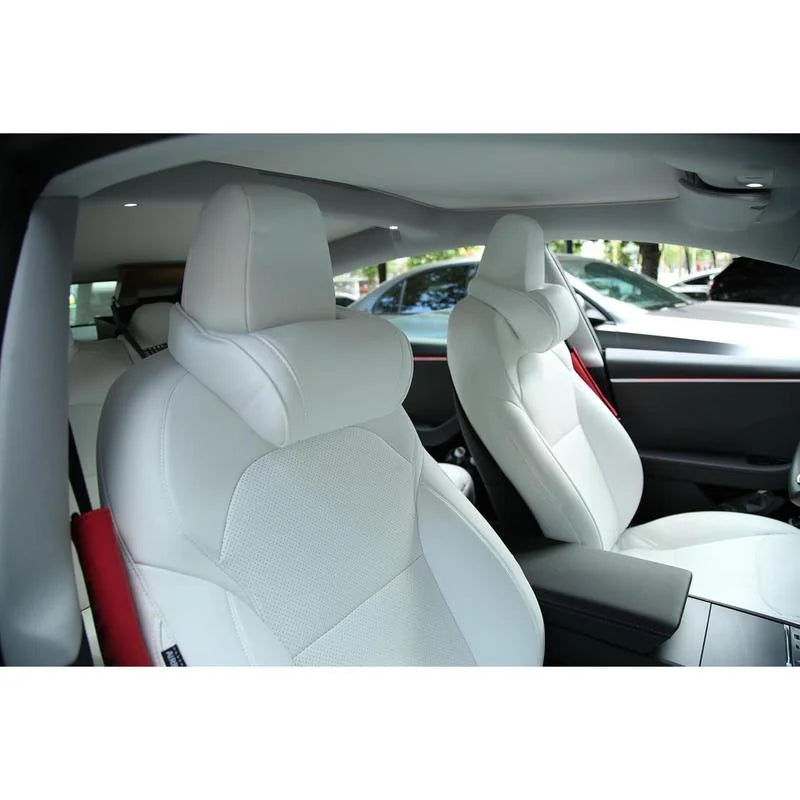 White neck pillow installed on a Tesla front seat headrest